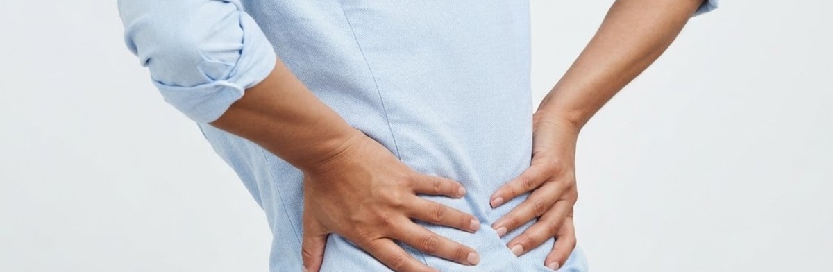 Person with hands pressed on lower back showing back pain